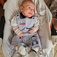 Thyméo a rejoint le concours — aidez-le/la à gagner de superbes lots ! baby, baby_seat, bear_patch, blanket, child, clothing, comfort, cute, cute_expression, happy, indoor, infant, overalls, person, portrait, seat, smile, socks, soft, toddler