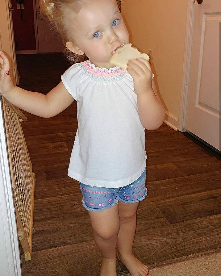 Chasity is registered to the contest to win money with this photo: abdomen, blouse, child, clothing, day, girl, human_hair_color, infant, joint, leg, person, product, shorts, shoulder, skin, sleeve, standing, textile, toddler, top