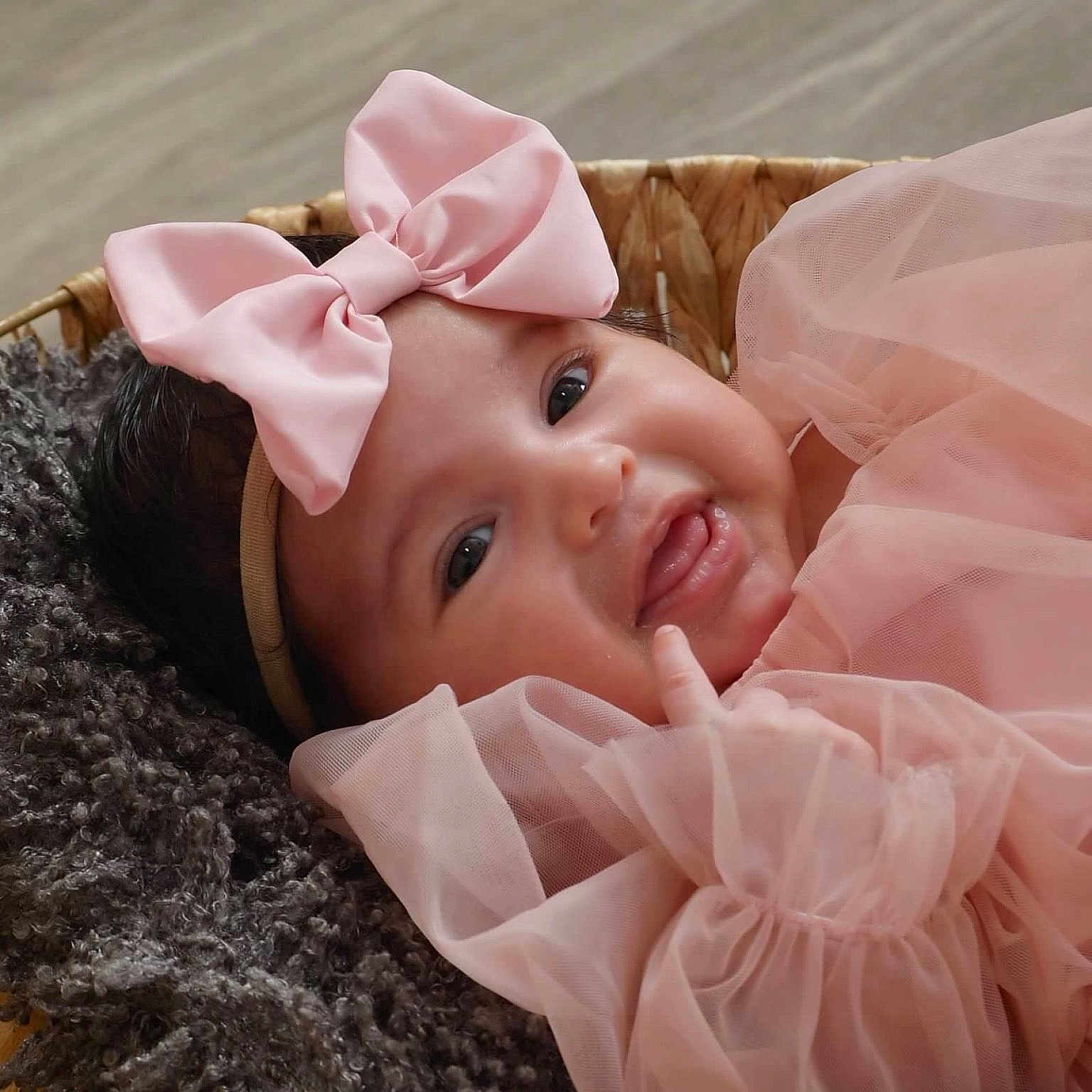 Coco is registered to the contest to win money with this photo: adorable, baby, baby_girl, basket, blanket, child, close_up, cozy, cute, face, happy, headband, infant, newborn, pink_bow, pink_dress, portrait, smiling, soft_texture, tulle