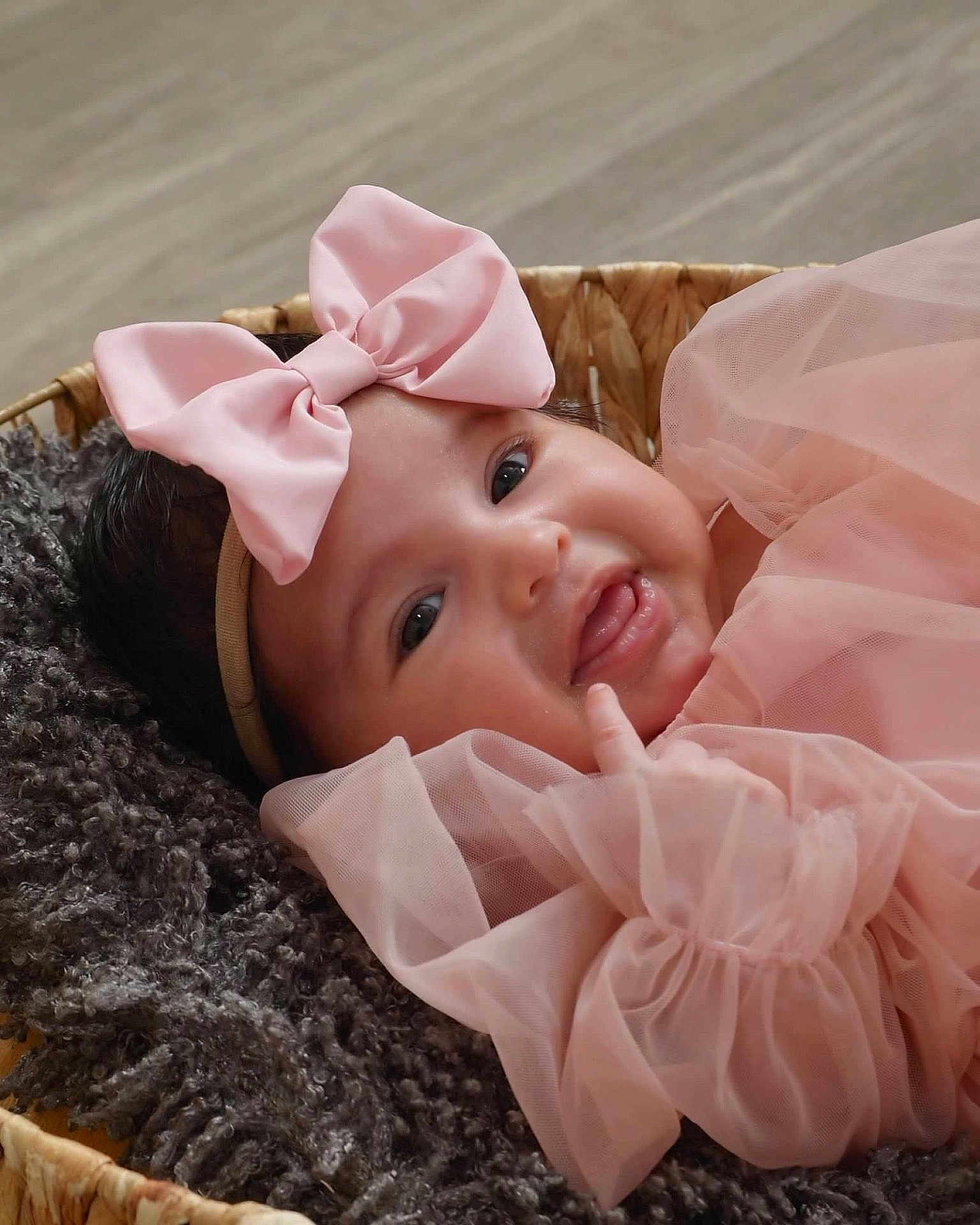 Coco is registered to the contest to win money with this photo: adorable, baby, baby_girl, basket, blanket, child, close_up, cozy, cute, face, happy, headband, infant, newborn, pink_bow, pink_dress, portrait, smiling, soft_texture, tulle