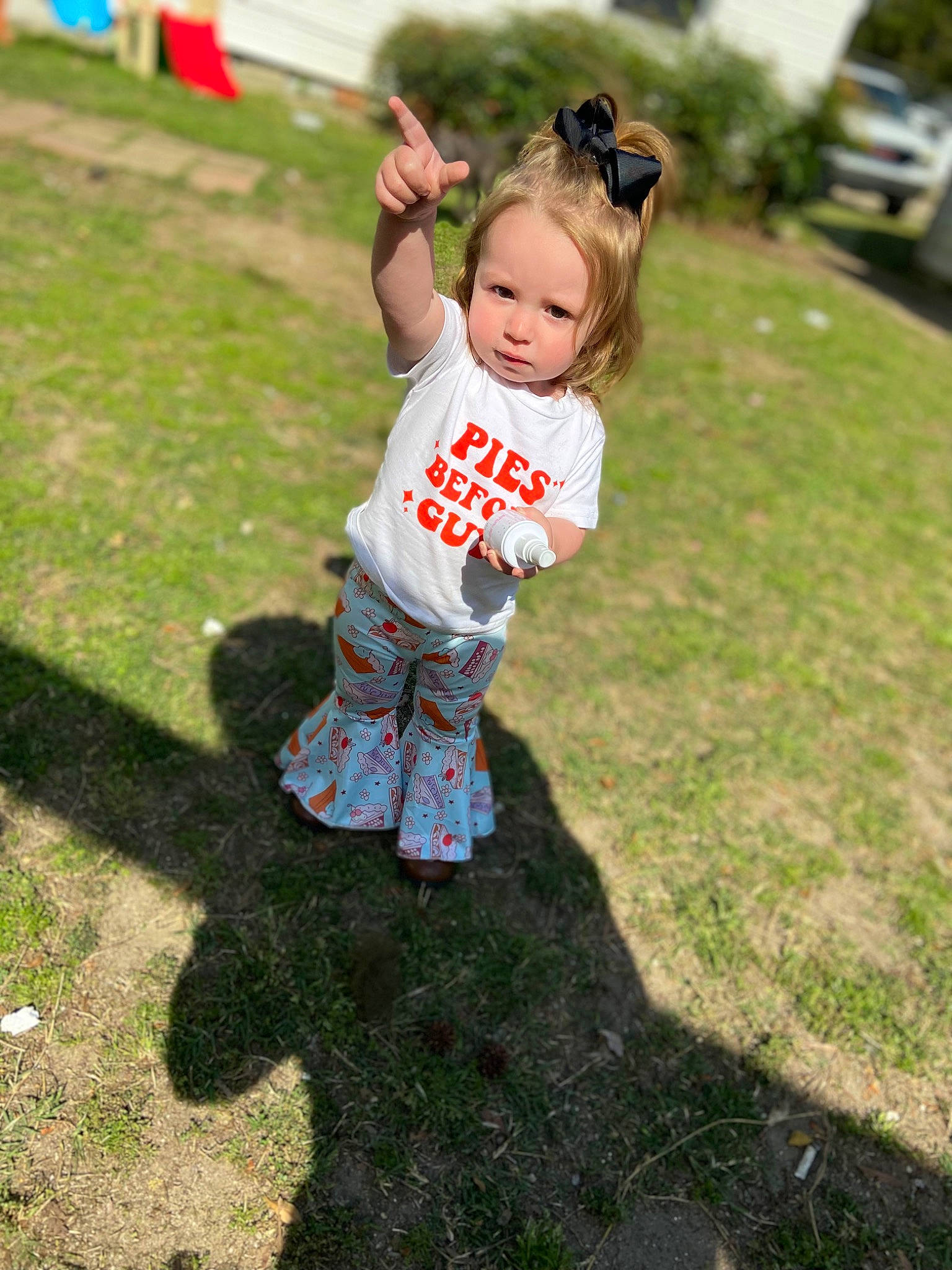 Hazley is registered to the contest to win money with this photo: baby, child, flag, fun, grass, grassland, happy, jeans, lawn, leisure, person, plant, play, recreation, sleeve, soil, sunglasses, t_shirt, toddler, woody_plant