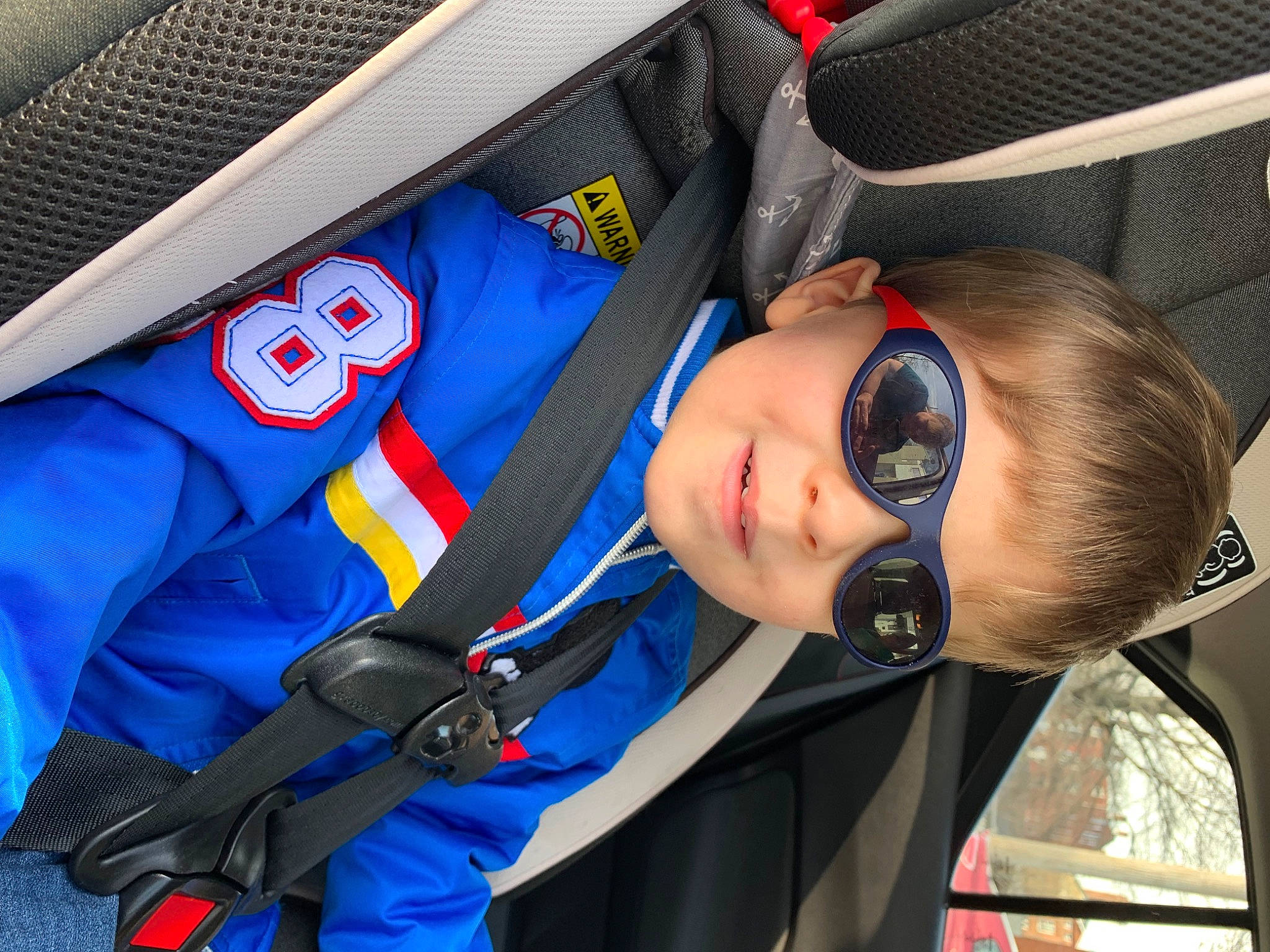 Austin is registered to the contest to win money with this photo: auto_part, automotive_design, automotive_exterior, baby_carriage, car_seat, carmine, child, comfort, design, electric_blue, eyewear, motor_vehicle, outerwear, person, personal_protective_equipment, product, recreation, sunglasses, toddler, uniform