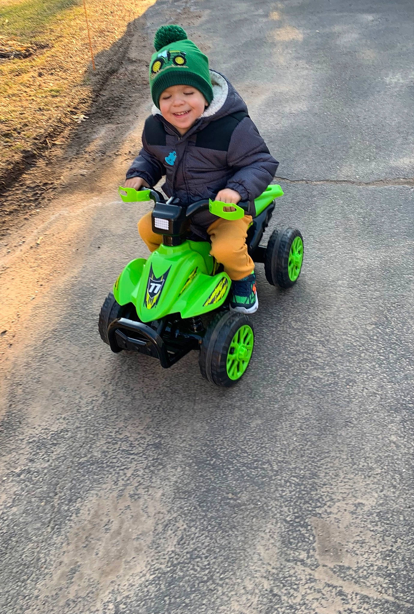 Austin is registered to the contest to win money with this photo: asphalt, auto_part, automotive_tire, automotive_wheel_system, baby, bicycle, bicycle_accessory, bicycle_helmet, grass, headwear, helmet, joy, motor_vehicle, person, personal_protective_equipment, recreation, riding_toy, rolling, tire, toddler