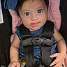 baby, blue_bow, bracelet, car_seat, child, closeup, clothing, cute, expression, hands, headband, indoor, infant, person, pink_cushion, portrait, safety_harness, seatbelt, tongue_out, wide_eyes