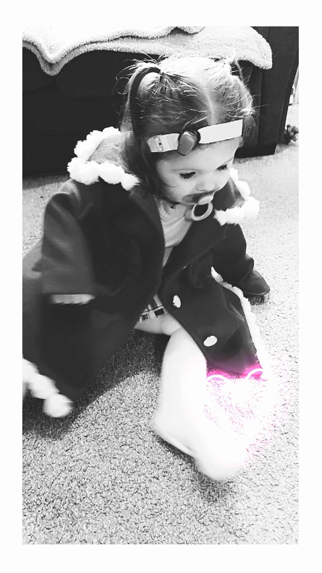 Harper is registered to the contest to win money with this photo: toddler, child, pacifier, headband, coat, carpet, floor, indoor, black_and_white, cute, sitting, baby, clothing, portrait, infant, warm_clothing, furniture, cozy, young_child, heart_glow