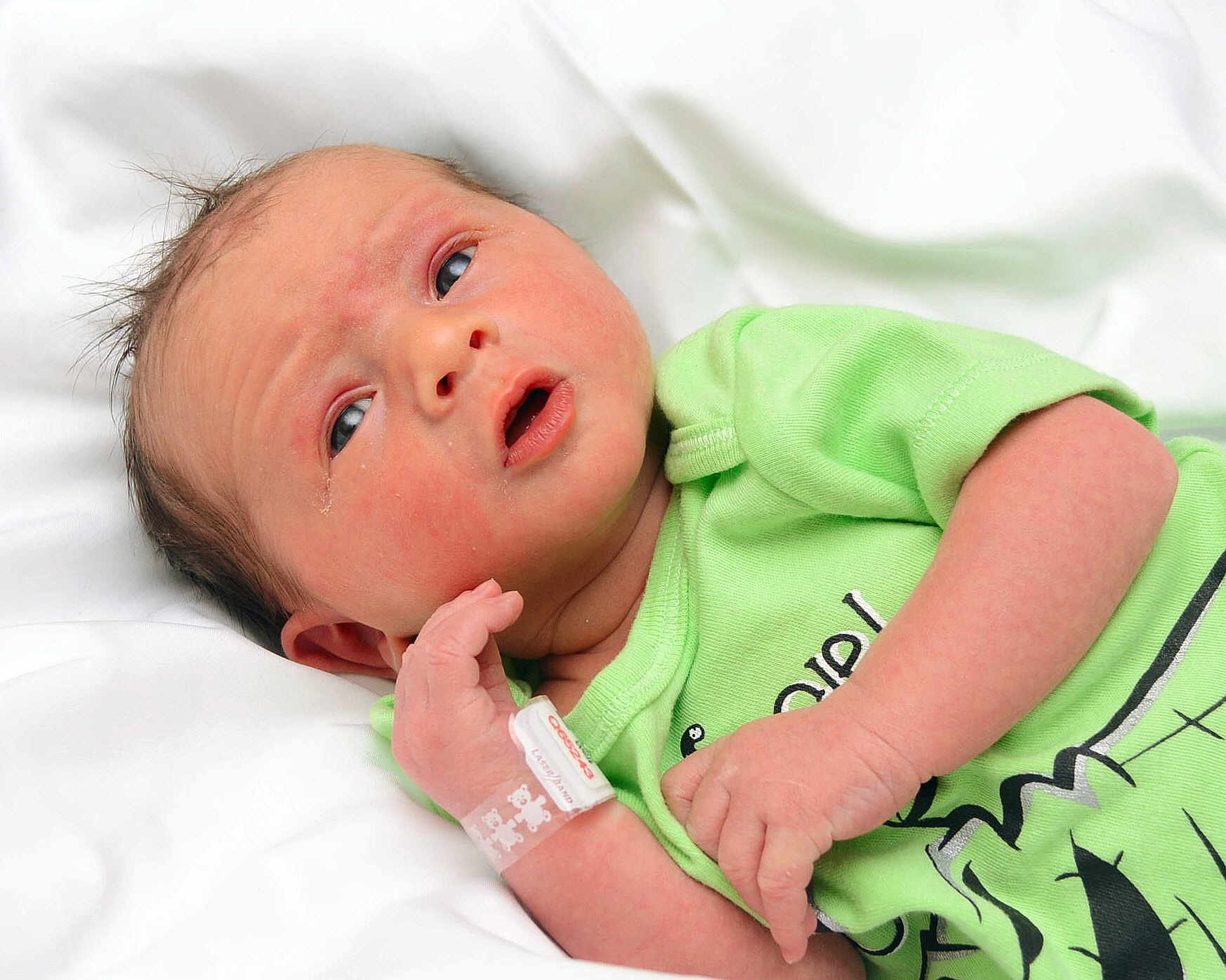 Logan is registered to the contest to win money with this photo: architecture, arm, baby, bodypart, building, clothing, crying, face, finger, glove, hand, head, hospital, newborn, person, photography, portrait, sad, t_shirt, wrist