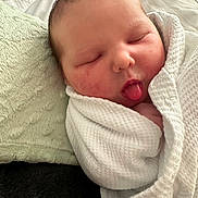 Kamrynn is registered to the contest to win money with this photo: newborn, baby, sleeping, tongue_out, blanket, wrapped, soft, pillow, white, face, infant, cute, peaceful, resting, indoors, skin, human, child, closeup, portrait