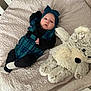 Kamrynn is registered to the contest to win money with this photo: baby, infant, teddy_bear, plush_toy, blanket, crib, headband, clothing, cute, child, bedroom, soft_toy, resting, indoors, comfort, sleepwear, black_clothing, blue_clothing, lying_down, peaceful