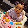 baby, infant, child, pigtails, bows, walker, toy, indoor, floor, curious, pink, purple, clothing, hair, face, expression, seat, play, cute, person