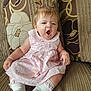 baby, blond_hair, child, couch, cute, fabric, home, indoor, infant, pacifier, patterned_cushion, pink_dress, plush, ponytail, portrait, sitting, sleepy, sofa, white_socks, yawning