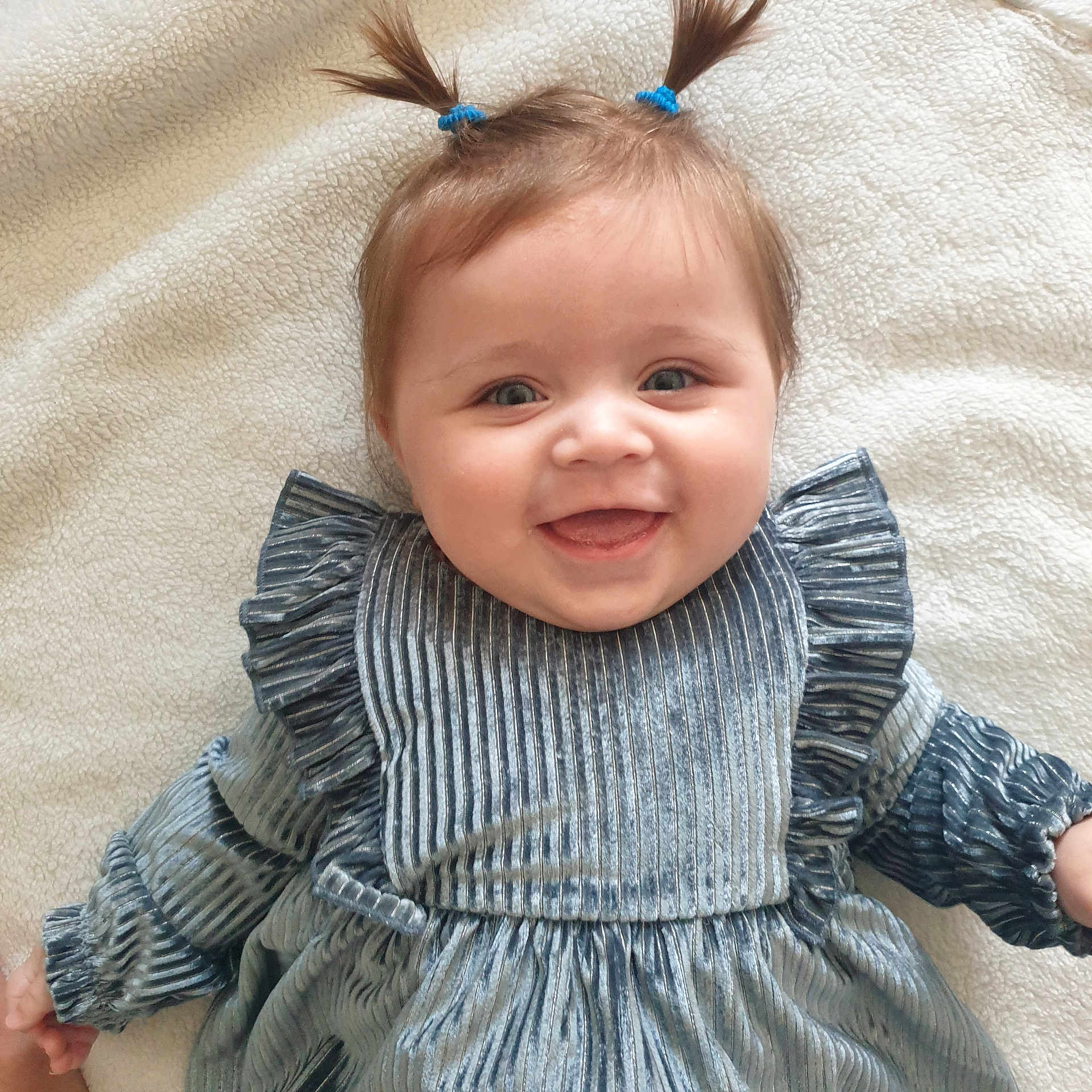 Bonnie joined the competition — help win amazing prizes! baby, child, smiling, pigtails, blue_dress, velvet, texture, happy, face, portrait, infant, cute, lying_down, blanket, soft, young_child, person, indoor, hands, joyful
