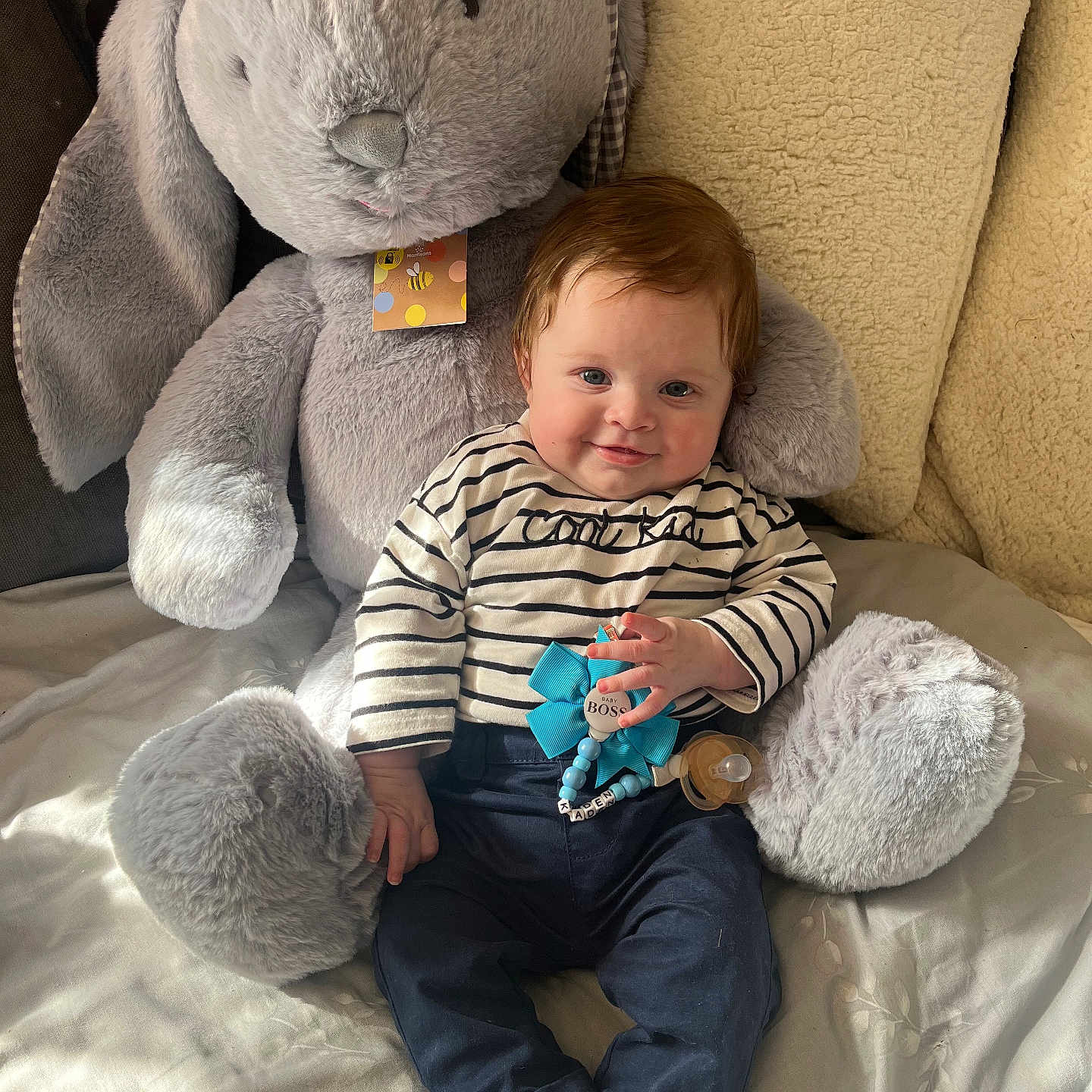 Kaden joined the competition — help win amazing prizes! baby, bodypart, clothing, couch, creditcard, cushion, face, finger, furniture, hand, head, homedecor, pants, person, photography, plush, portrait, sitting, text, toy