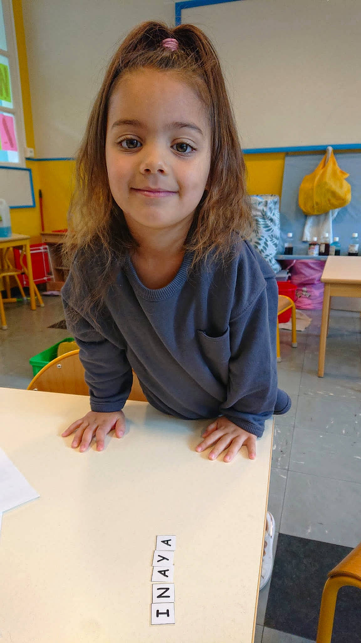 Inaya a rejoint le concours — aidez-le/la à gagner de superbes lots ! chair, child, class, education, event, fun, joy, learning, person, room, school, sitting, smile, stationery, t_shirt, table, toddler, visual_arts, writing, writing_implement