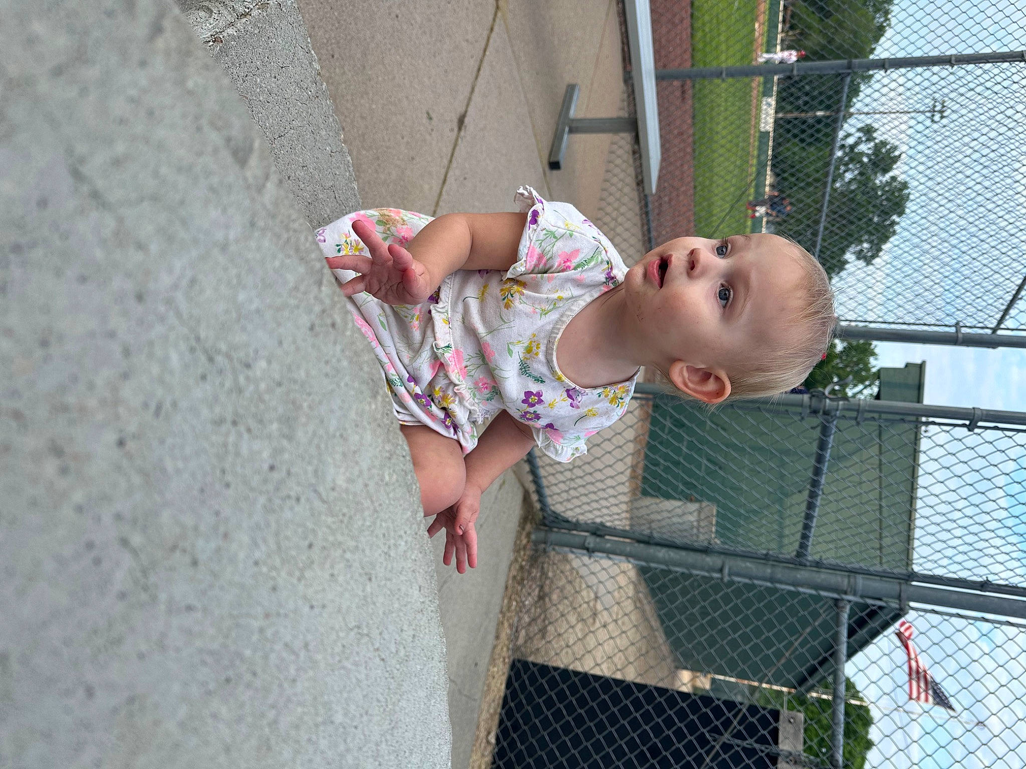 Kailena Krueger joined the competition — help win amazing prizes! baby, baby_toddler_clothing, chain_link_fencing, child, city, concrete, face, fence, fun, human_leg, leisure, mesh, net, person, recreation, sidewalk, sitting, skin, surprise, toddler