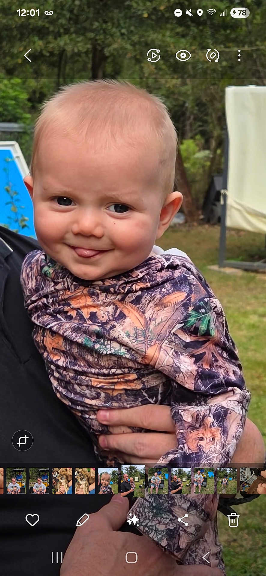 Barrett joined the competition — help win amazing prizes! baby, child, smiling, outdoor, camouflage_clothing, person, face, tongue, hand, grass, garden, portrait, cute, holding, young_child, nature, expression, happy, head, skin
