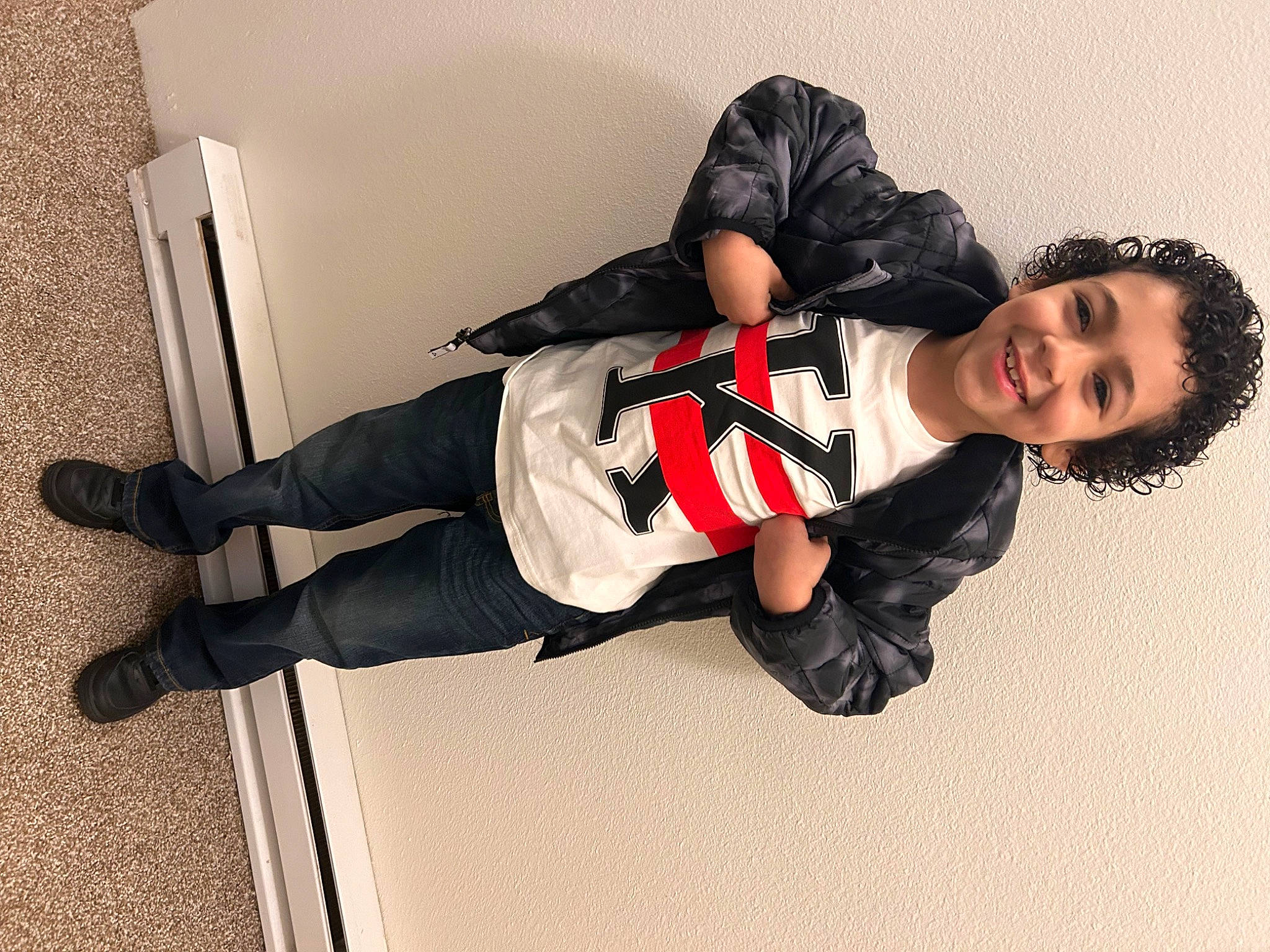 Izaiah is registered to the contest to win money with this photo: carmine, collar, costume, eyewear, fashion_design, footwear, happy, joy, knee, leg, outdoor_shoe, person, shoe, sitting, sleeve, smile, sneakers, sportswear, thigh, uniform