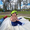 Embyr joined the competition — help win amazing prizes! baby, child, blanket, park, grass, trees, cap, neon_green, spray_bottle, blue_sky, clouds, smiling, casual_clothing, outdoor, nature, footwear, person, socks, playful, relaxing
