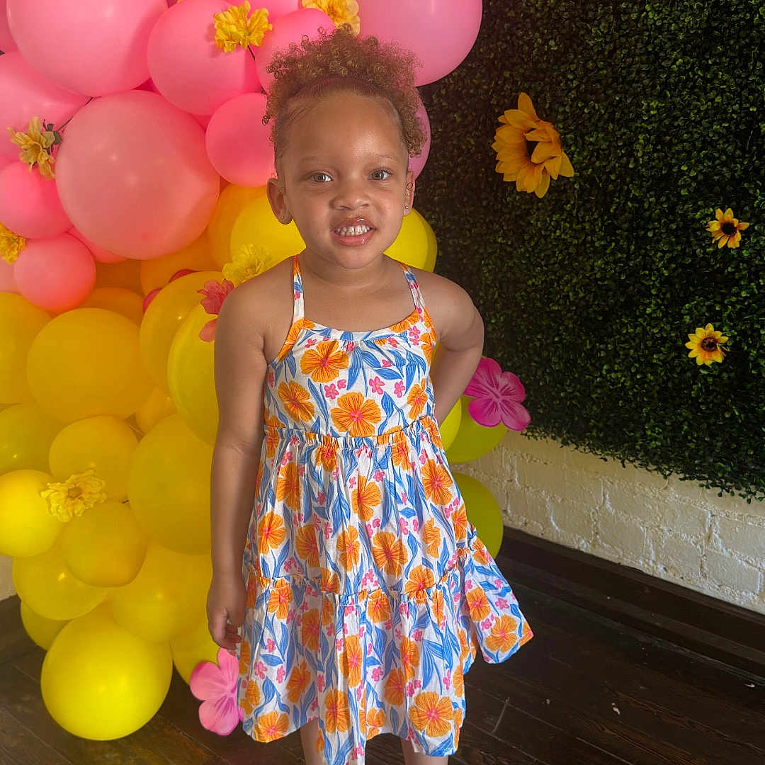 Kali is registered to the contest to win money with this photo: balloon, child, clothing, dress, eveningdress, face, female, flower, flowerarrangement, footwear, formalwear, girl, head, person, photography, plant, portrait, sandal, sphere, wood