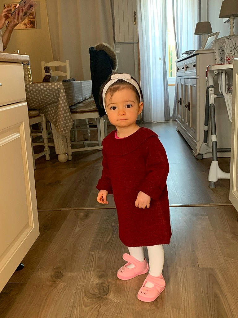 Célia a rejoint le concours — aidez-le/la à gagner de superbes lots ! baby, child, clothing, costume, dress, floor, flooring, hardwood, joint, outerwear, person, pink, room, shoe, shoulder, sleeve, standing, toddler, wood, wood_flooring