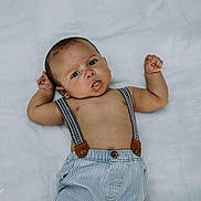Jaleel is registered to the contest to win money with this photo: baby, infant, child, suspenders, striped_pants, lying_down, white_background, cute, curious, portrait, skin, arms_up, expression, adorable, young, one_person, casual_clothing, indoors, baby_face, small_hands