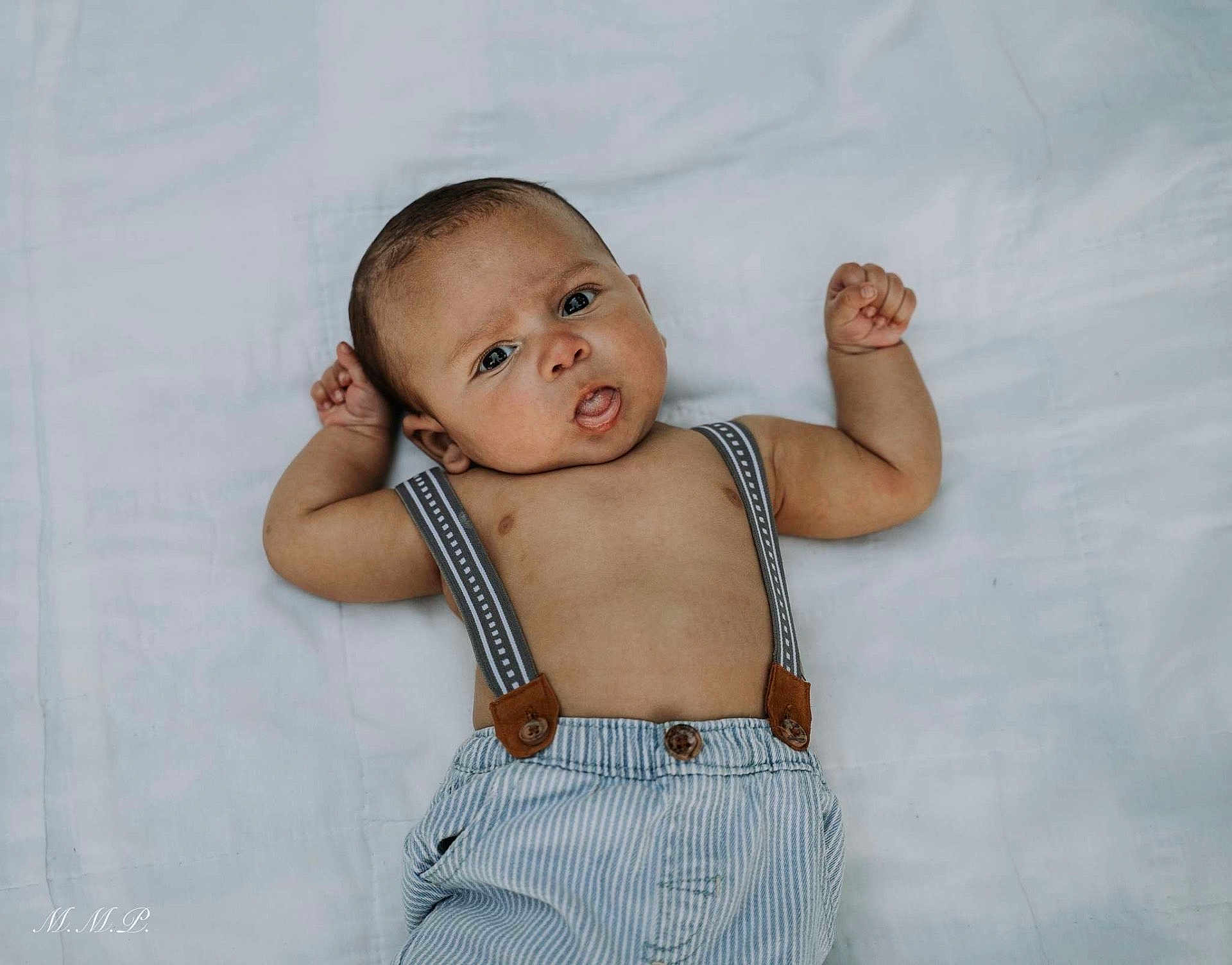 Jaleel is registered to the contest to win money with this photo: baby, infant, child, suspenders, striped_pants, lying_down, white_background, cute, curious, portrait, skin, arms_up, expression, adorable, young, one_person, casual_clothing, indoors, baby_face, small_hands