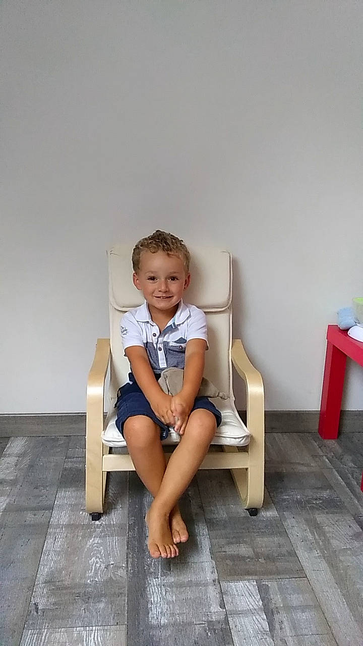 Enzo participe au concours pour gagner de l'argent avec cette photo : barefoot, chair, child, flooring, furniture, human_leg, joy, leg, person, room, shoe, sitting, table, toddler, vacation, wood