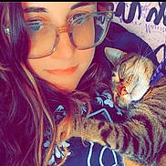 Nala is registered to the contest to win money with this photo: casual, cat, close_up, collar, comfort, cuddle, eyewear, face, glasses, happy, indoor, long_hair, paw, person, portrait, relaxed, sleeping_cat, snuggle, tabby_cat, warm