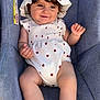 baby, baby_accessory, car_seat, casual, child, clothing_pattern, cute, footwear, happy, hat, indoor, infant, portrait, red_hearts, seated, shoes, smiling, sun_hat, white_clothing, young_child