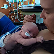 Damon joined the competition — help win amazing prizes! baby, newborn, hospital, medical_equipment, nasal_tube, adult, care, love, skin, intimate, resting, person, closeup, healthcare, mother, infant, tenderness, bedside, emotion, support
