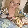 woman, baby, newborn, hospital_bed, medical_tubes, blanket, glasses, hat, patient, indoor, healthcare, care, resting, illness, medical_device, bed, person, tired, holding, closeup
