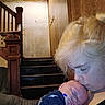 Damon is registered to the contest to win money with this photo: child, baby, infant, newborn, holding, caring, staircase, wood, indoor, face, person, medical_tubes, resting, blond_hair, cozy, home, wall, furniture, portrait, love