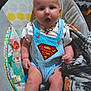 Jasper joined the competition — help win amazing prizes! baby, infant, superman_outfit, blue_overalls, baby_chair, blanket, indoor, cute, child, clothing, expression, toy, comfort, face, legs, sitting, colorful, pattern, person, home