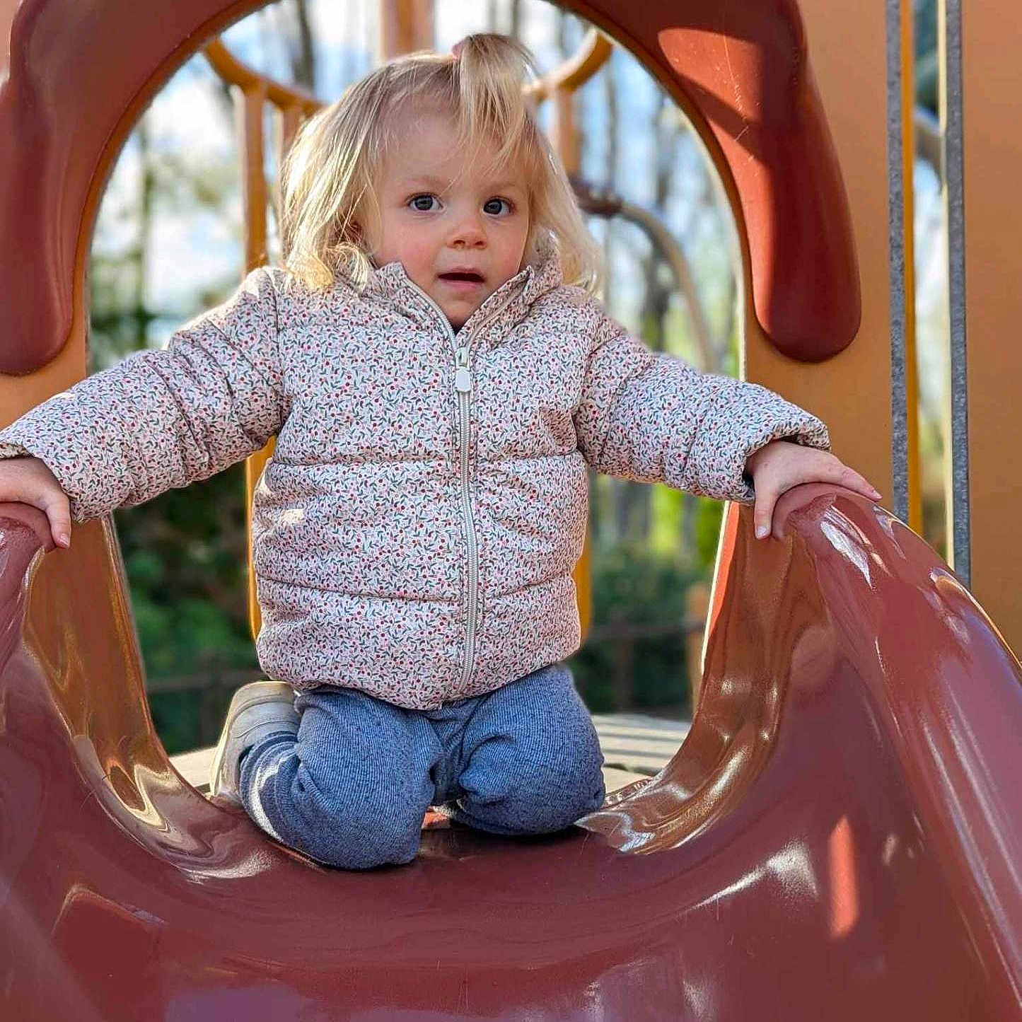 Lyv participe au concours pour gagner de l'argent avec cette photo : baby, clothing, coat, face, head, indoors, jeans, outdoorplayarea, outdoors, pants, person, playarea, sitting, slide, sliding, toy