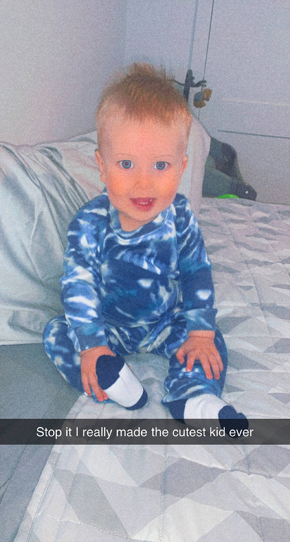 Daxton is registered to the contest to win money with this photo: baby, baby_toddler_clothing, child, comfort, couch, electric_blue, finger, flooring, fun, happy, head, human_body, pattern, person, photo_caption, room, sitting, sleeve, smile, t_shirt