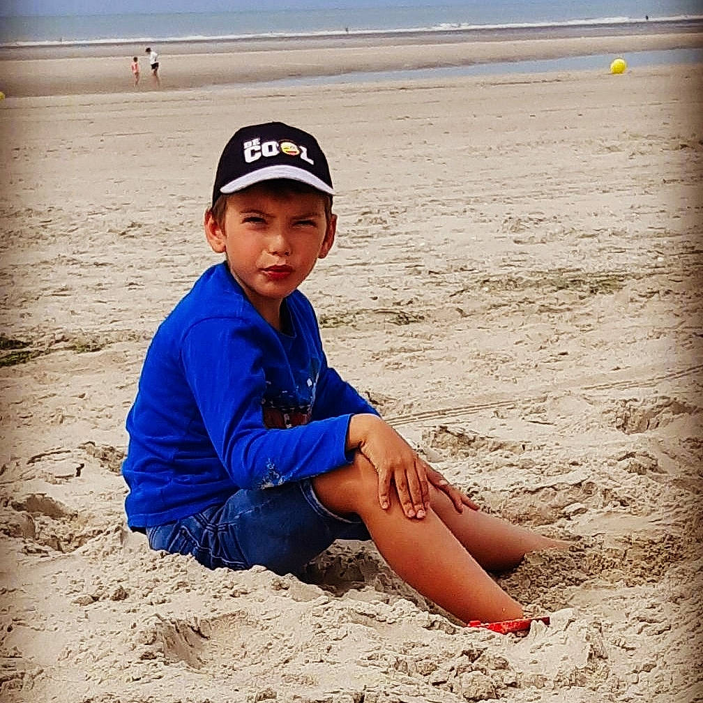 Mattéo a rejoint le concours — aidez-le/la à gagner de superbes lots ! baseball_cap, beach, cap, cool, electric_blue, fun, happy, hat, headwear, horizon, knee, landscape, leisure, morning, people_in_nature, people_on_beach, person, sand, shore, t_shirt