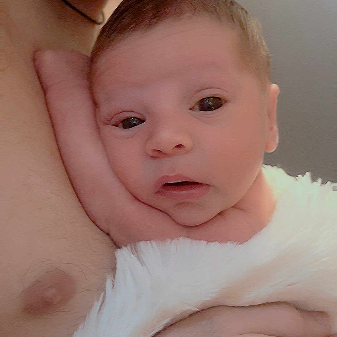 Lorenzo joined the competition — help win amazing prizes! adult, baby, blanket, caring, chest, closeup, comfort, expression, face, hand, holding, indoors, infant, newborn, parent, person, skin, soft, tender, warmth