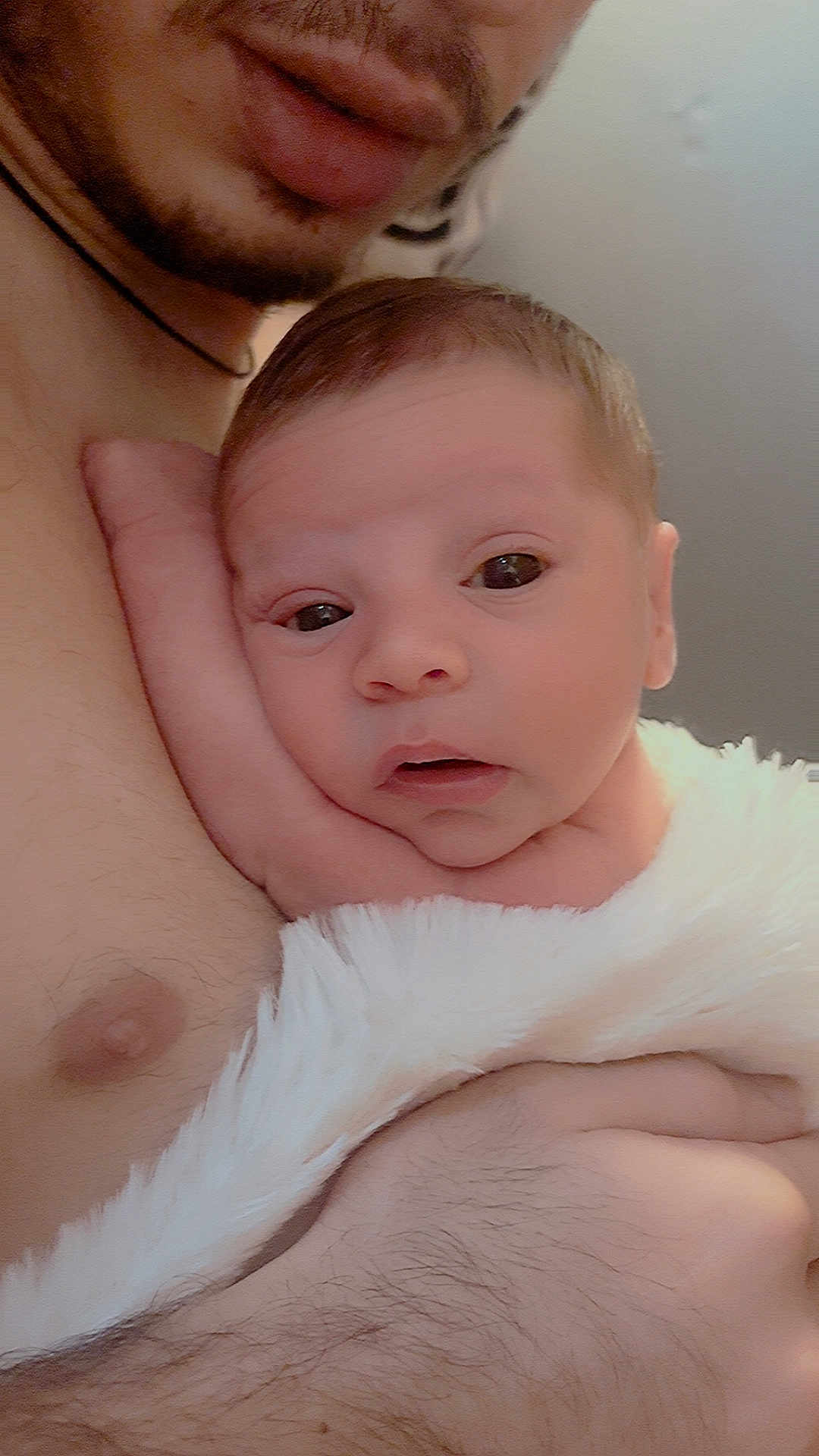 Lorenzo joined the competition — help win amazing prizes! baby, newborn, infant, adult, skin, chest, blanket, closeup, face, hand, comfort, warmth, parent, holding, soft, expression, indoors, person, caring, tender