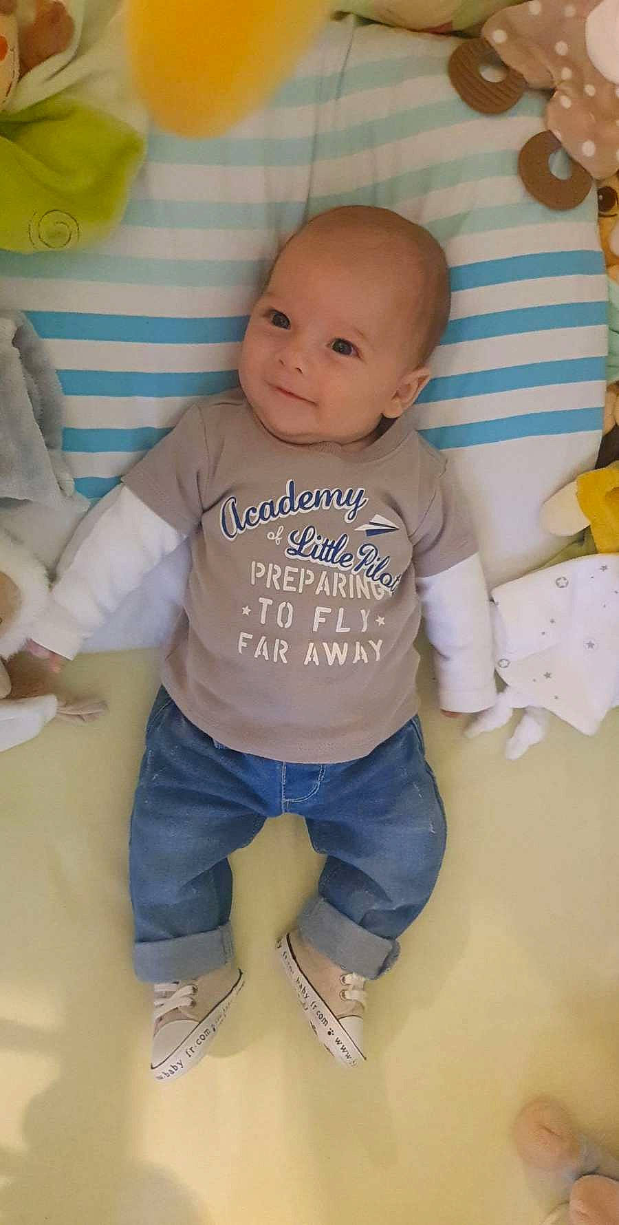 Timaé a rejoint le concours — aidez-le/la à gagner de superbes lots ! baby, baby_products, baby_toddler_clothing, cheek, child, electric_blue, eye, flooring, fun, happy, head, knee, linens, person, sitting, skin, sleeve, smile, t_shirt, textile