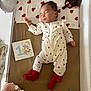 baby, sleeping, crib, onesie, red_hearts, soft_toys, pacifier, milestone_card, infant, blanket, sleep, cute, child, toy, bed, comfort, rest, indoor, person, peaceful