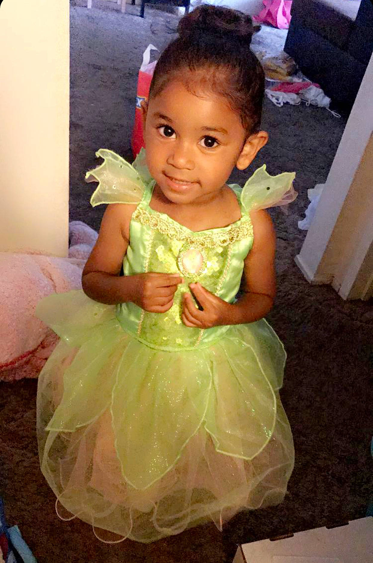 Aniyah is registered to the contest to win money with this photo: baby_toddler_clothing, child, clothing, day_dress, dress, embellishment, event, face, formal_wear, fun, hair, happy, head, human_body, iris, joy, person, pink, ruffle, smile