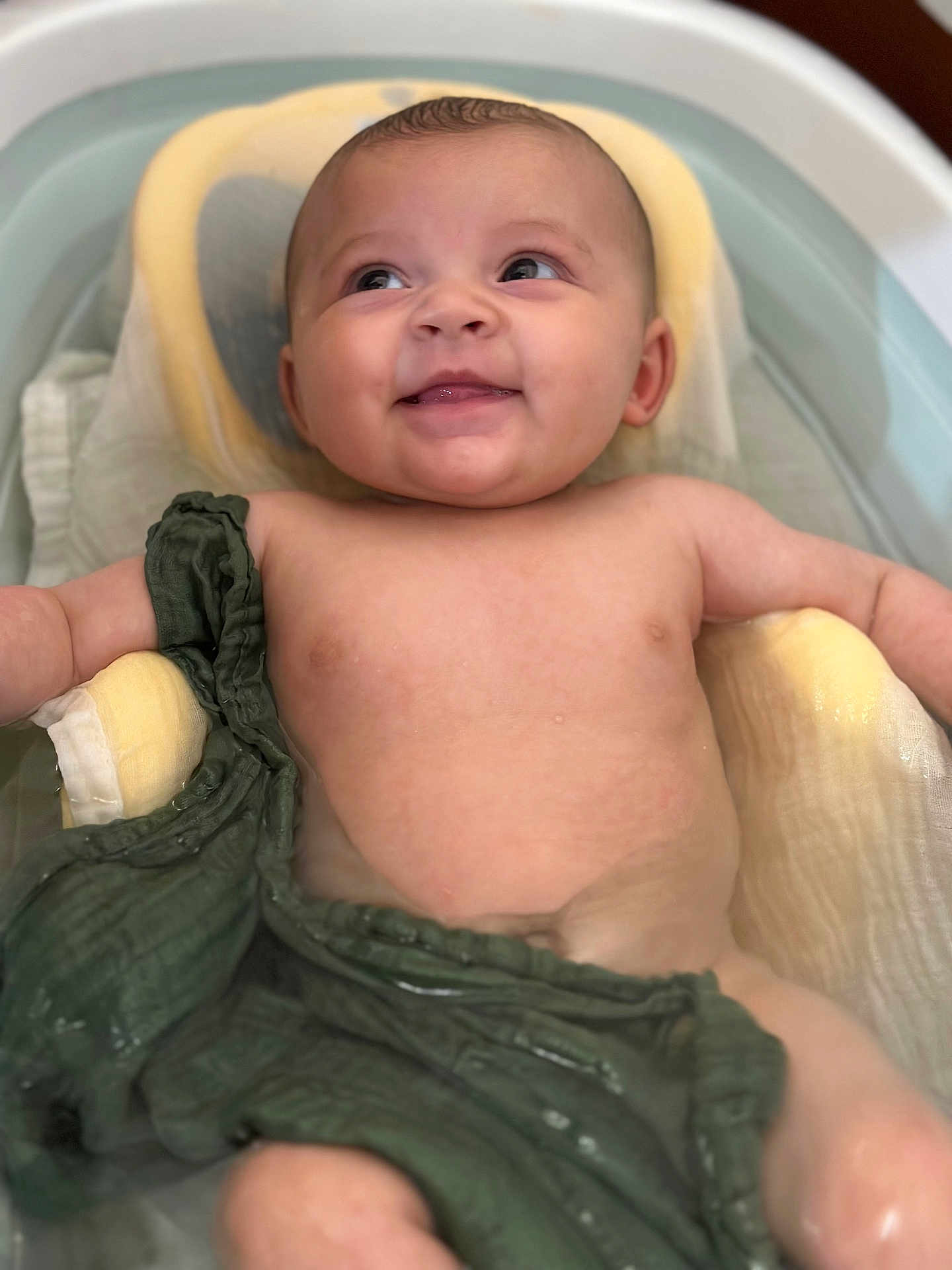 Felicia a rejoint le concours — aidez-le/la à gagner de superbes lots ! baby, infant, smiling, bath, water, skin, child, face, happy, relaxing, green_cloth, cushion, tub, head, eyes, mouth, arm, shoulder, young, cute