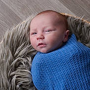 Kelvin joined the competition — help win amazing prizes! baby, infant, blanket, blue, basket, fur, cozy, wrapped, newborn, face, head, skin, expression, indoors, floor, wood, portrait, cute, small, child