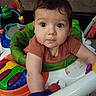baby, child, infant, portrait, face, eyes, wide_eyed, sitting, activity_center, jumper, baby_toys, colorful, indoor, home, brown_hair, short_sleeves, green, orange, white, curious