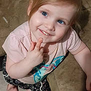 Mackenzie is registered to the contest to win money with this photo: toddler, child, blue_eyes, smiling, pink_shirt, patterned_shorts, barefoot, couch, indoor, floor, curly_hair, playful, happy, person, portrait, kneeling, cute, skin, fingertip, young_child