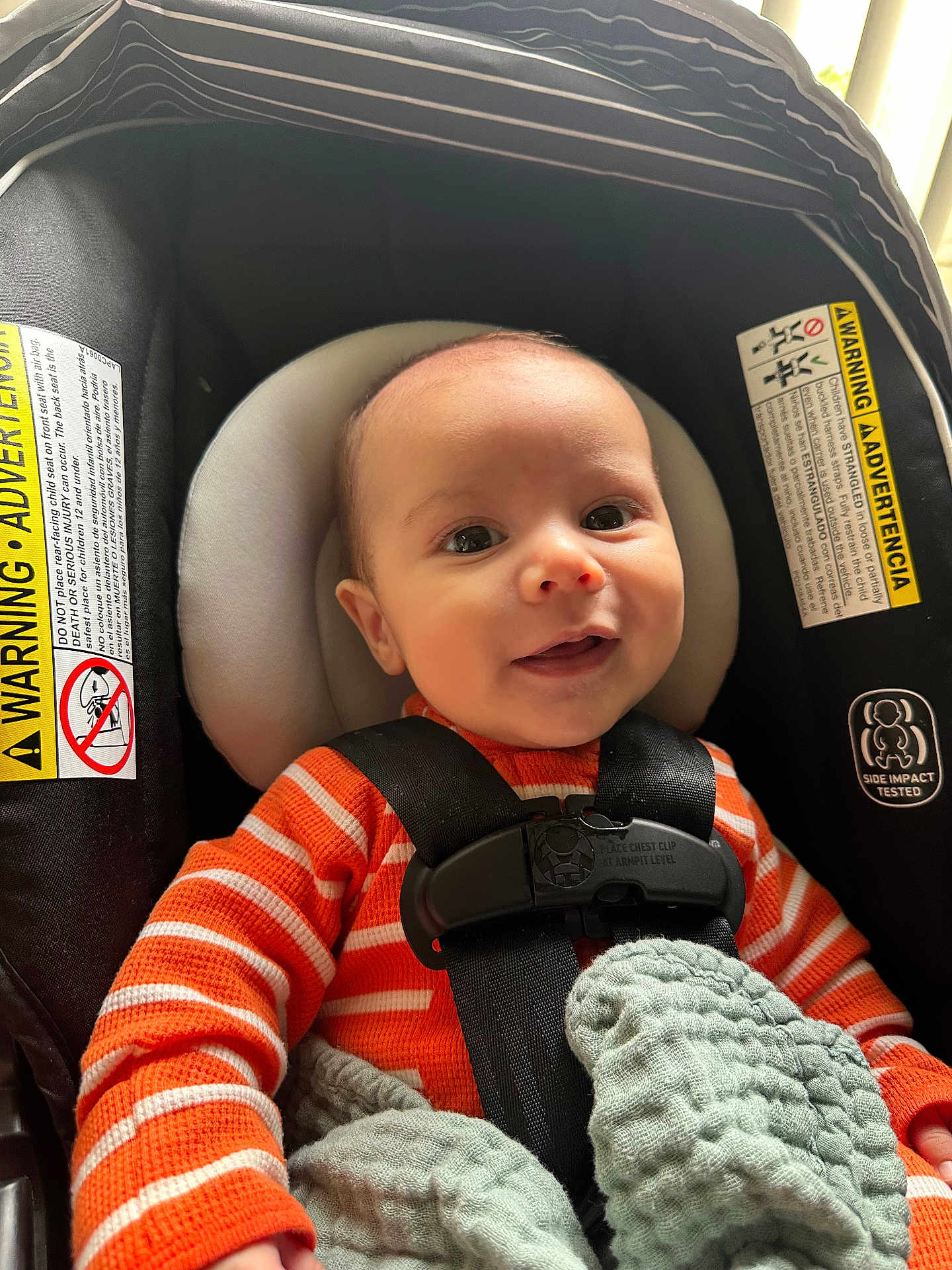 Jensen joined the competition — help win amazing prizes! baby, infant, car_seat, orange_sweater, striped_clothing, blanket, smiling, happy, child, face, head, seatbelt, safety_harness, indoor, human, cute, portrait, clothing, seat, comfort