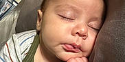 Jensen is registered to the contest to win money with this photo: baby, sleeping, infant, peaceful, hand, face, pillow, cozy, striped_clothing, soft_light, closeup, cute, resting, indoors, portrait, child, newborn, peace, calm, skin