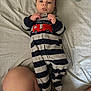 Jensen joined the competition — help win amazing prizes! baby, infant, striped_onesie, fire_truck, bed, bedspread, striped_bedspread, lying_down, hands, face, tattoo, leg, human, cute, curious, indoor, person, clothing, footed_pajamas, sleepwear