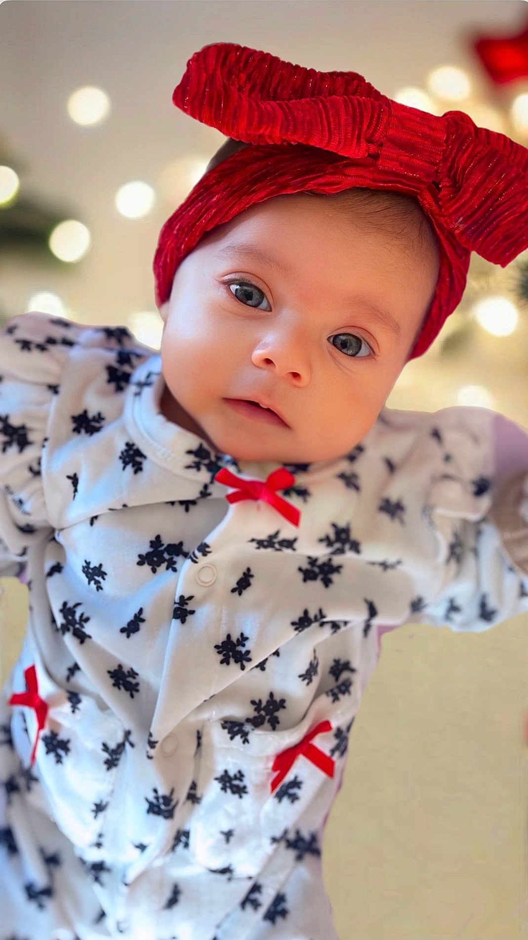 Ayla Serene is registered to the contest to win money with this photo: baby, infant, headband, red_bow, white_outfit, snowflake_pattern, red_ribbons, closeup, face, eyes, holiday, festive, cute, child, portrait, soft_lighting, indoors, warm_colors, clothing, smile