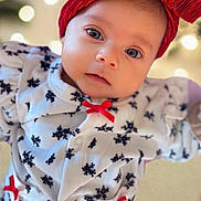 Ayla Serene joined the competition — help win amazing prizes! apparel, baby, bokeh, child, closeup, cute, expression, eyes, face, fashion, headband, holiday_theme, indoors, infant, portrait, red_bow, snowflake_pattern, soft_lighting, white_outfit, young