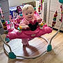 baby, child, pink_clothing, jumper, toy, minnie_mouse, playroom, floor, window, sunlight, face, smile, playful, indoor, furniture, colorful, baby_toys, happy, infant, seat